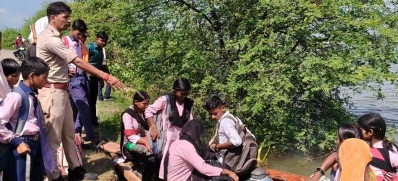 नाव में बैठकर स्कूल जाते बच्चे। नाव में बैठकर स्कूल जाते बच्चे।
