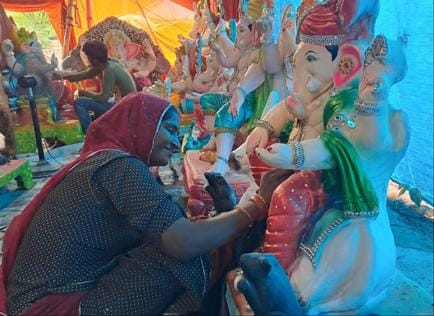 151....श्री गणेश की प्रतिमा का श्रृंगार करती महिला। संवाद