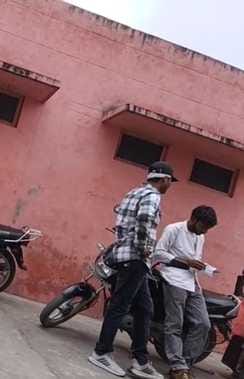 जिला अस्पताल के गेट नंबर दो पर सीटी स्कैन कराने के एवज में सफेद कोट पहने रुपए लेता दलाल। संवाद।