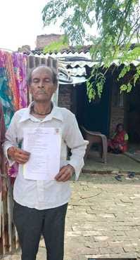 सरकारी सबूत मिलने के बाद घर के दरवाजे पर खड़े घर के मालिक स्रोत नगर पंचायत