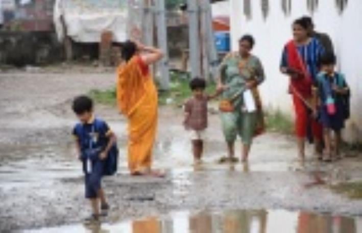 जलभराव से गुजरते लोग। जलभराव से गुजरते लोग।