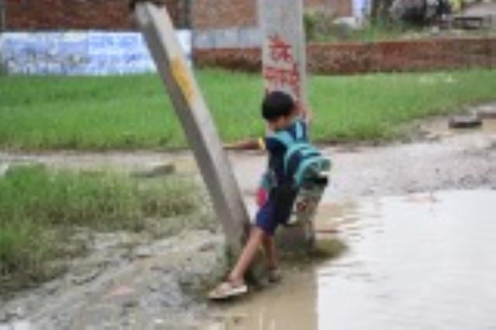 जलभराव से गुजरते लोग। जलभराव से गुजरते लोग।