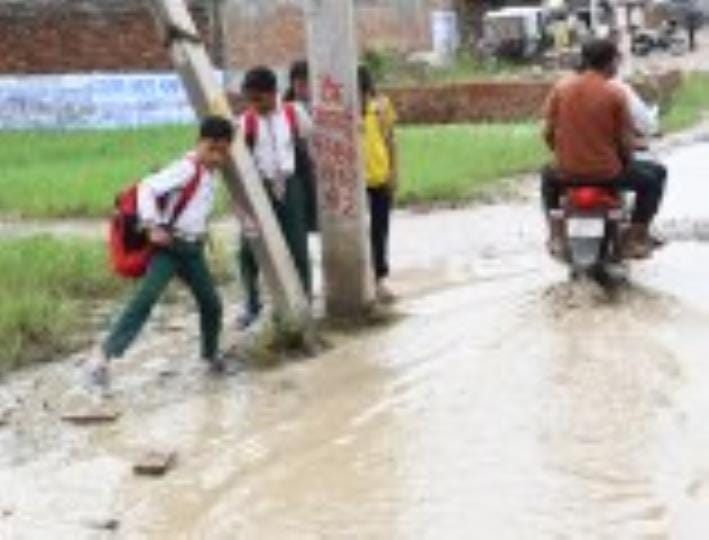 जलभराव से गुजरते लोग। जलभराव से गुजरते लोग।