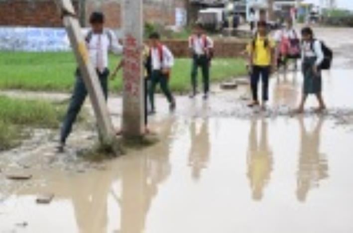 जलभराव से गुजरते लोग। जलभराव से गुजरते लोग।