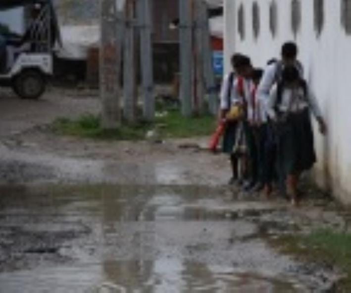 जलभराव से गुजरते लोग। जलभराव से गुजरते लोग।