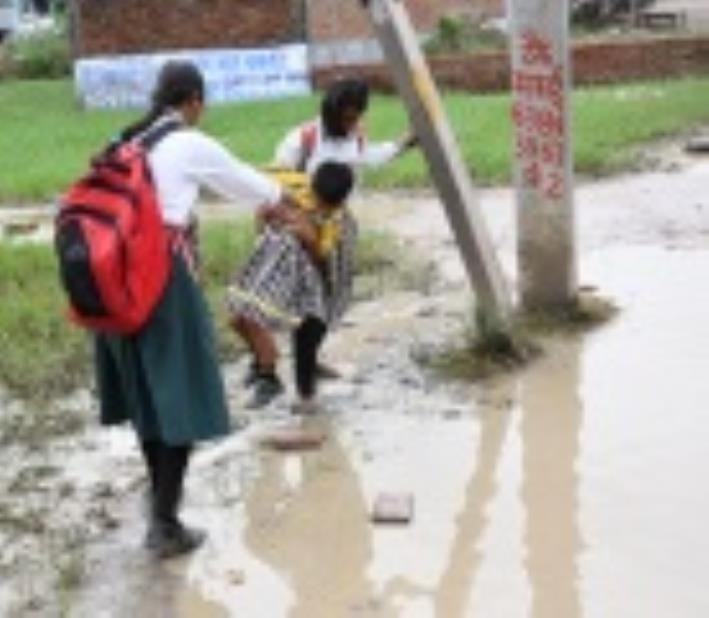 जलभराव से गुजरते लोग। जलभराव से गुजरते लोग।