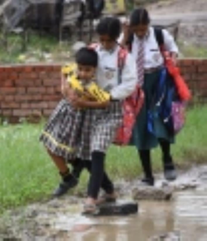 जलभराव से गुजरते लोग। जलभराव से गुजरते लोग।