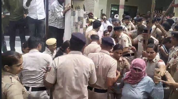 27जेएनडी28-करेला गांव में मकान पर कब्जा कार्रवाई के दौरान ग्रामीणों को समझाते हुए पुलिसकर्मी। स