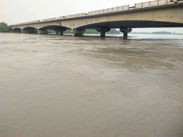 खोजकीपुर गांव में कटाव रोकने कके लिए मिट्टी के कट्टे लगाते मजदूर। संवाद