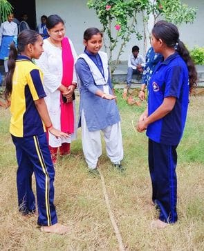 27. आलापुर के प्राथमिक विद्यालय अक्षती में पिरामिड बनाकर झंडा रोहण करता विद्यार्थी।-स्रोत विद्य