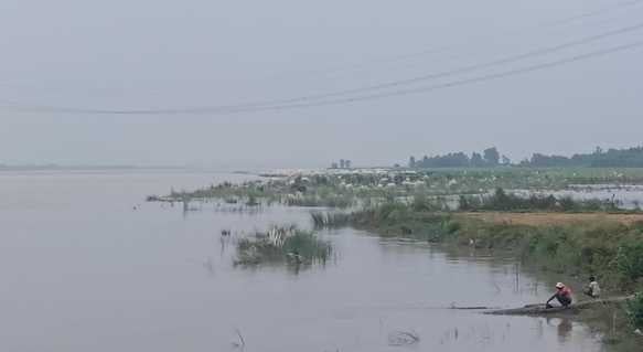 ऊन में  बारिश से  जलभराव के बीच से जाते बाइक  सवार । संवाद