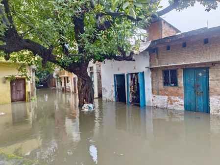 चूड़ी बाजार में जलभराव से गुजरते लोग। संवाद चूड़ी बाजार में जलभराव से गुजरते लोग। संवाद