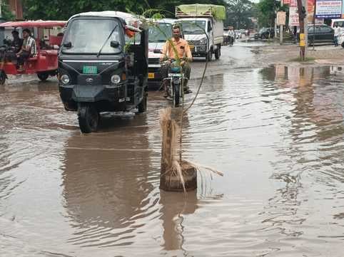 चूड़ी बाजार में जलभराव से गुजरते लोग। संवाद चूड़ी बाजार में जलभराव से गुजरते लोग। संवाद