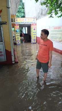 चूड़ी बाजार में जलभराव से गुजरते लोग। संवाद चूड़ी बाजार में जलभराव से गुजरते लोग। संवाद