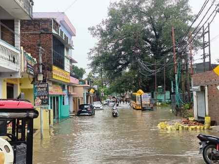चूड़ी बाजार में जलभराव से गुजरते लोग। संवाद चूड़ी बाजार में जलभराव से गुजरते लोग। संवाद