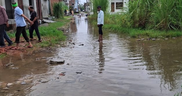 बिजनौर में सोमवार को बारिश में छाता लगाकर जाती युवती। संवाद बिजनौर में सोमवार को बारिश में छाता लगाकर जाती युवती। संवाद