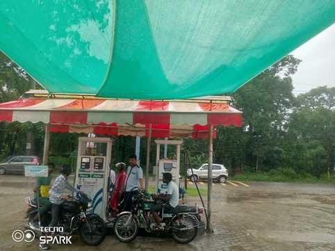 बीसलपुर के बिलसंडा रोड स्थित पंप के बाहर हेलमेट लेकर खड़ा कर्मचारी। संवाद