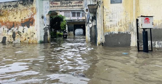 जोगीपुरा में स्थित दुकान में भरा पानी, बाहर बैठे दुकानदार। संवाद