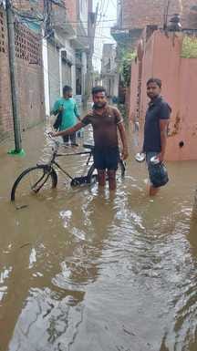 शहर की नेहरू मार्केट में बारिश से हुए जलभराव के बीच से गुंजरते वाहन व लोग। संवाद शहर की नेहरू मार्केट में बारिश से हुए जलभराव के बीच से गुंजरते वाहन व लोग। संवाद