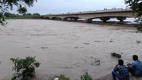 यमुना में बढ़ते जलस्तर को देखते ग्रामीण। संवाद यमुना में बढ़ते जलस्तर को देखते ग्रामीण। संवाद