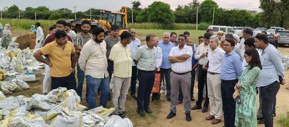 03jjrp18- सिलानी गांव के पास ड्रेन के ओवरफ्लो होने पर कट्टे रखते ग्रामीण व कर्मी। संवाद