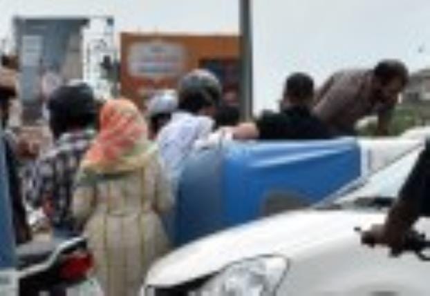 1090 चौराहे पर पलटी ऑटो में बैठी सवारियों को बाहर निकालते लोग।
