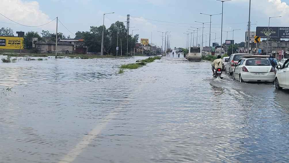 मुलाना में एनएच 344 पर जलभराव से गुजरते वाहन। संवाद मुलाना में एनएच 344 पर जलभराव से गुजरते वाहन। संवाद