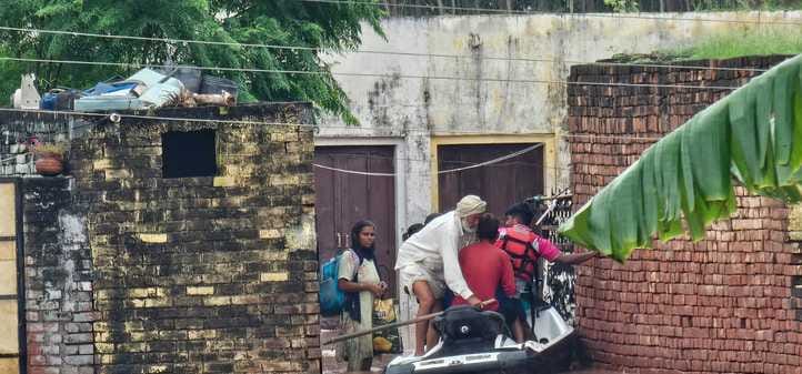 निजामपुर गांव से ग्रामीणों को किश्ती में रेस्क्यू करते हुए टीम। स्त्रोत निजामपुर गांव से ग्रामीणों को किश्ती में रेस्क्यू करते हुए टीम। स्त्रोत