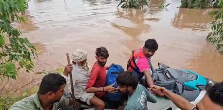 निजामपुर गांव से ग्रामीणों को किश्ती में रेस्क्यू करते हुए टीम। स्त्रोत निजामपुर गांव से ग्रामीणों को किश्ती में रेस्क्यू करते हुए टीम। स्त्रोत