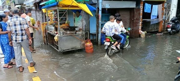 फोटो- 10 दुकान से पानी निकालता दुकानदार।संवाद फोटो- 10 दुकान से पानी निकालता दुकानदार।संवाद