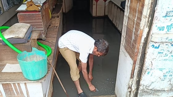 फोटो- 10 दुकान से पानी निकालता दुकानदार।संवाद फोटो- 10 दुकान से पानी निकालता दुकानदार।संवाद