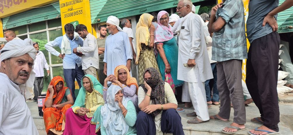 फोटो संख्या:70- कनीना में डीएपी खाद को लेकर अपनी बारी का इंतजार में बैठे किसान--संवाद
