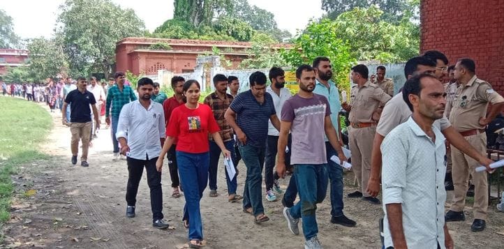 पीईटी देने के बाद अभ्यर्थी अपना सामान लेते हुए। संवाद
