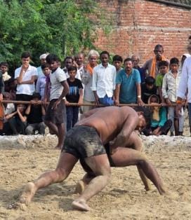 दंगल में दांव लगाते पहलवान। दंगल में दांव लगाते पहलवान।