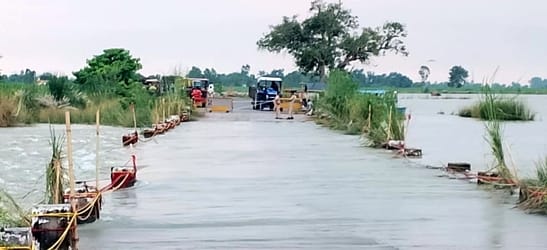 जलालाबाद के ग्राम कसारी में पानी भरे रास्ते से निकलते ग्रामीण। संवाद जलालाबाद के ग्राम कसारी में पानी भरे रास्ते से निकलते ग्रामीण। संवाद