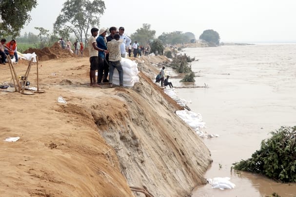 बिजनौर में गंगा बैराज के तटबंध के कटान को रोकने के लिए मिट्टी से भरे कट्टे लगाते मजदूर। सवाद बिजनौर में गंगा बैराज के तटबंध के कटान को रोकने के लिए मिट्टी से भरे कट्टे लगाते मजदूर। सवाद