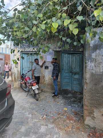 फतेहाबाद के पुरानी तहसील चौक क्षेत्र में जर्जर भवनों को गिराने को लेकर नोटिस लगाते हुए कर्मचारी