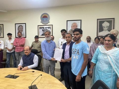 कुरुक्षेत्र। प्रर्दशन के दौरान बहस करते छात्र व कुलसचिव डॉ. विरेंद्र पाल। संवाद