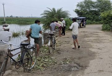 कल्याणी नदी के बढ़े जलस्तर से गांव में भरे पानी के बीच से निकलते बच्चे। स्रोत: पाठक