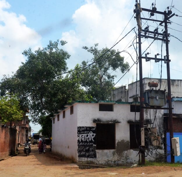 शहर के प्राथमिक विद्यालय जलालनगर के अंदर लगा बिजली का खंभा व ऊपर से गुजरी लाइन। संवाद