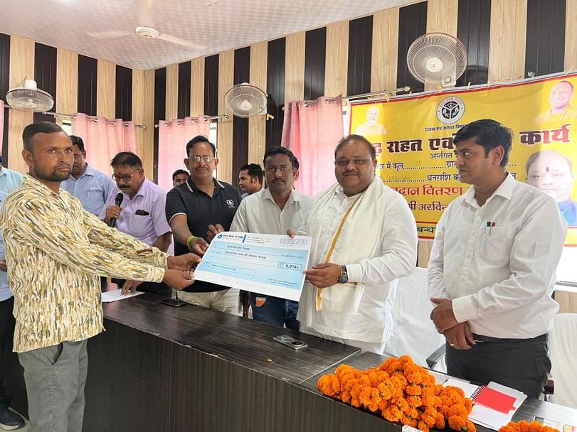 वित्तमंत्री कलक्ट्रेट सभागार में लाभार्थी को चेक वितरित करते हुए। स्रोत: सूचना विभाग