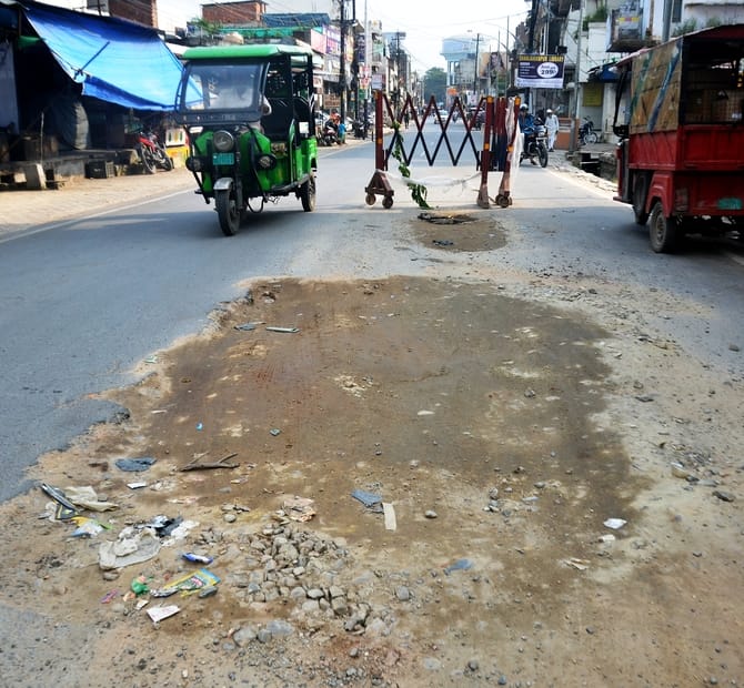 अशफाक नगर चौकी के पास सड़क पर उखड़ी पड़ी बजरी। संवाद