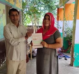 फोटो 40- सोनीपत के ग्रामीण क्षेत्र में उल्लास योजना के तहत परीक्षा से पूर्व महिला को स्टेशनरी द