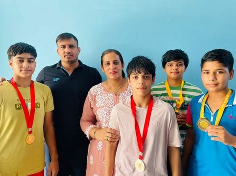 फोटो :36: सोनीपत के ककरोई रोड स्थित युद्धवीर अखाड़ा में अपने प्रशिक्षकों के साथ पदक विजेता पहलव