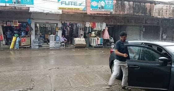 उझानी में पंखा रोड पर भरे बारिश के पानी में होकर निकलते वाहन। संवाद उझानी में पंखा रोड पर भरे बारिश के पानी में होकर निकलते वाहन। संवाद