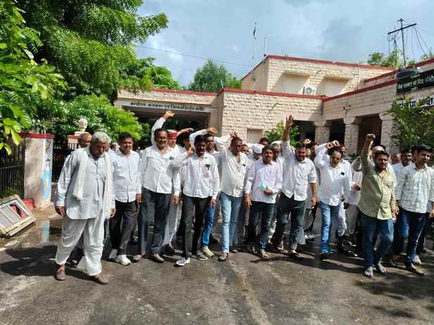 भीगी हुई फसल दिखता किसान