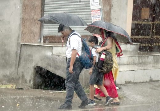 बिजनौर में सोमवार को बारिश में भीगती स्कूटी सवार युवती। संवाद