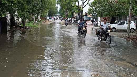जिमखाना रोड के पास बारिश में हुए जलभराव के बीच गुजरते वाहन। संवाद