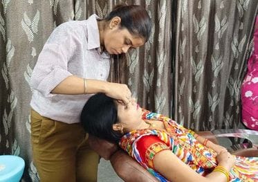 फोटो 09 एयूआरपी 16  महिला के हाथों में मेहंदी सजातीं युवतियां। संवाद
