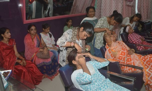 फोटो-10- सिनेमा रोड पर मेहंदी लगवाती महिलाएं। संवाद